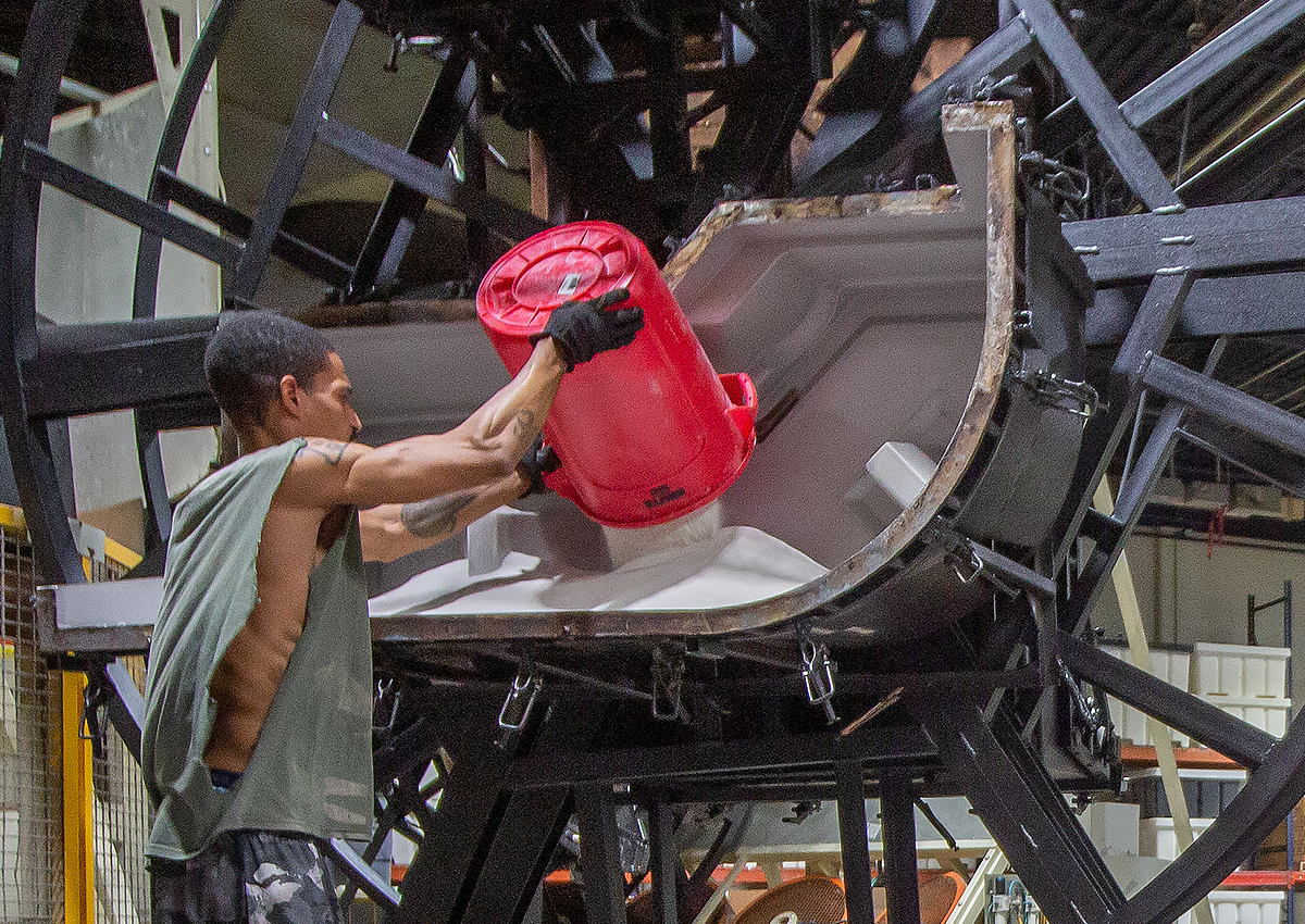 Man filling mold with plastic