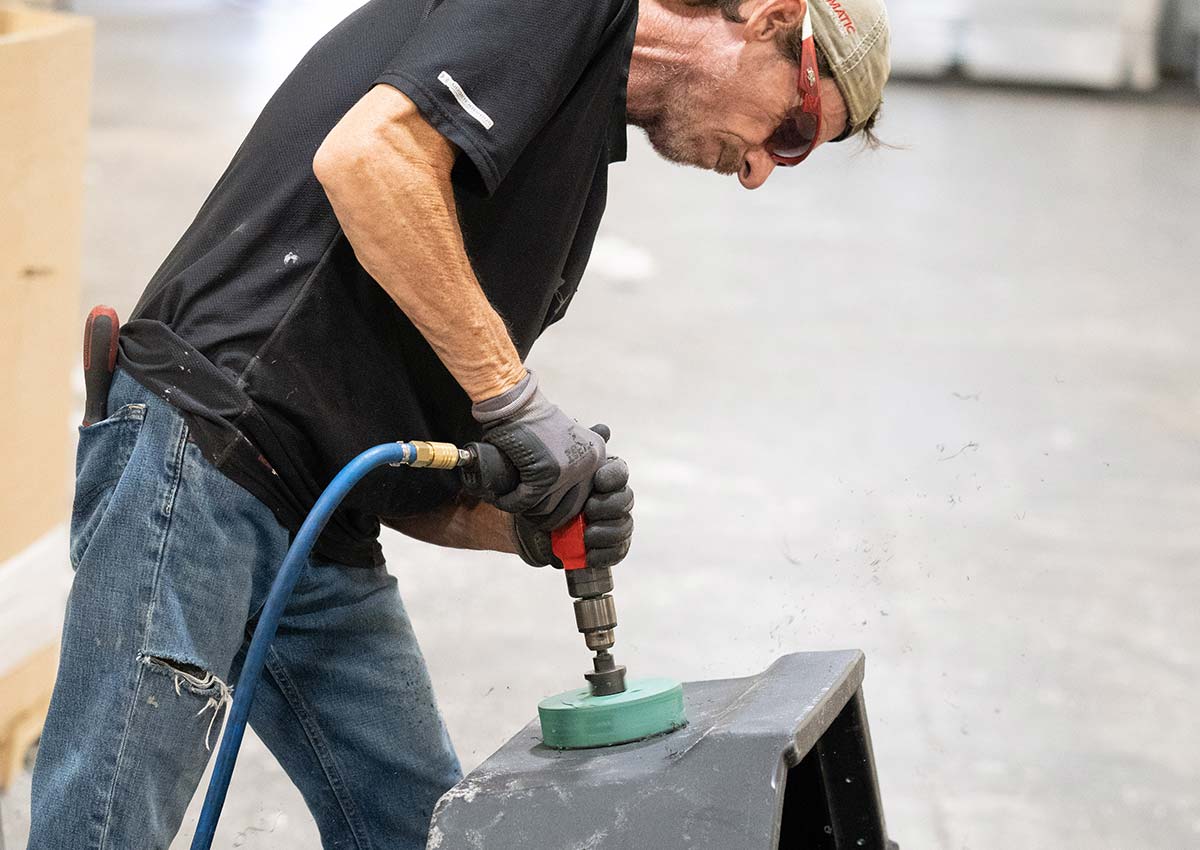 technician finish drilling a rotomolded part