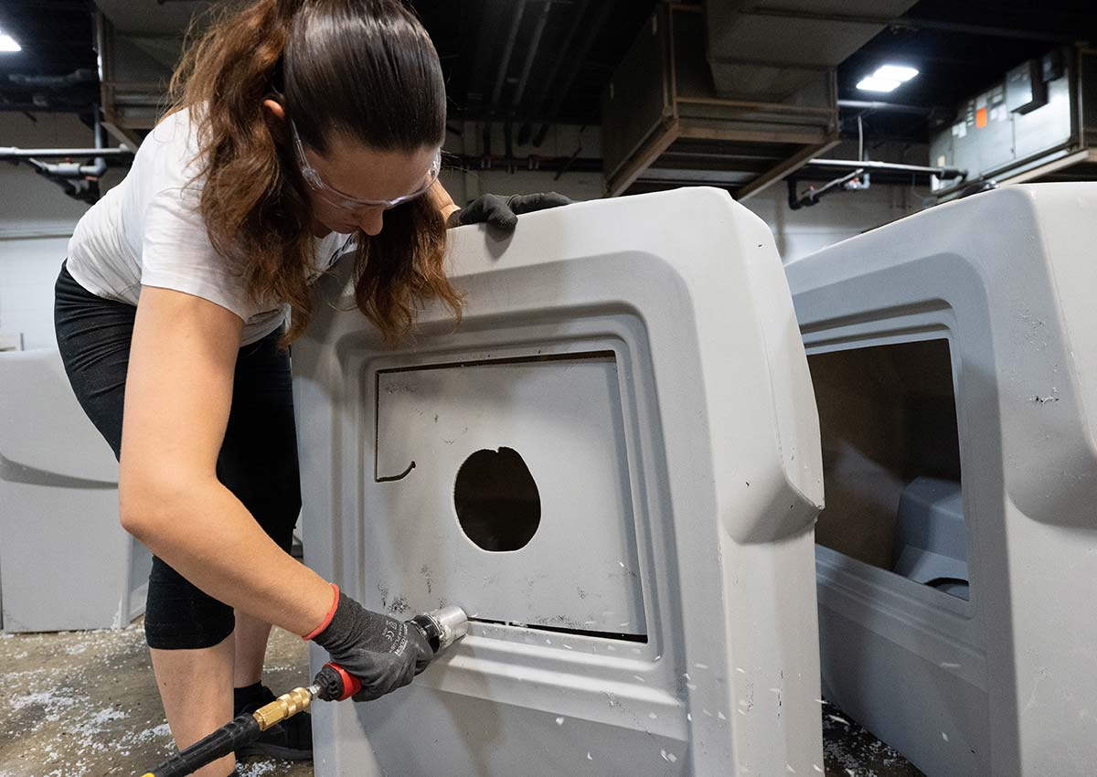 technician finish cutting a rotomolded part