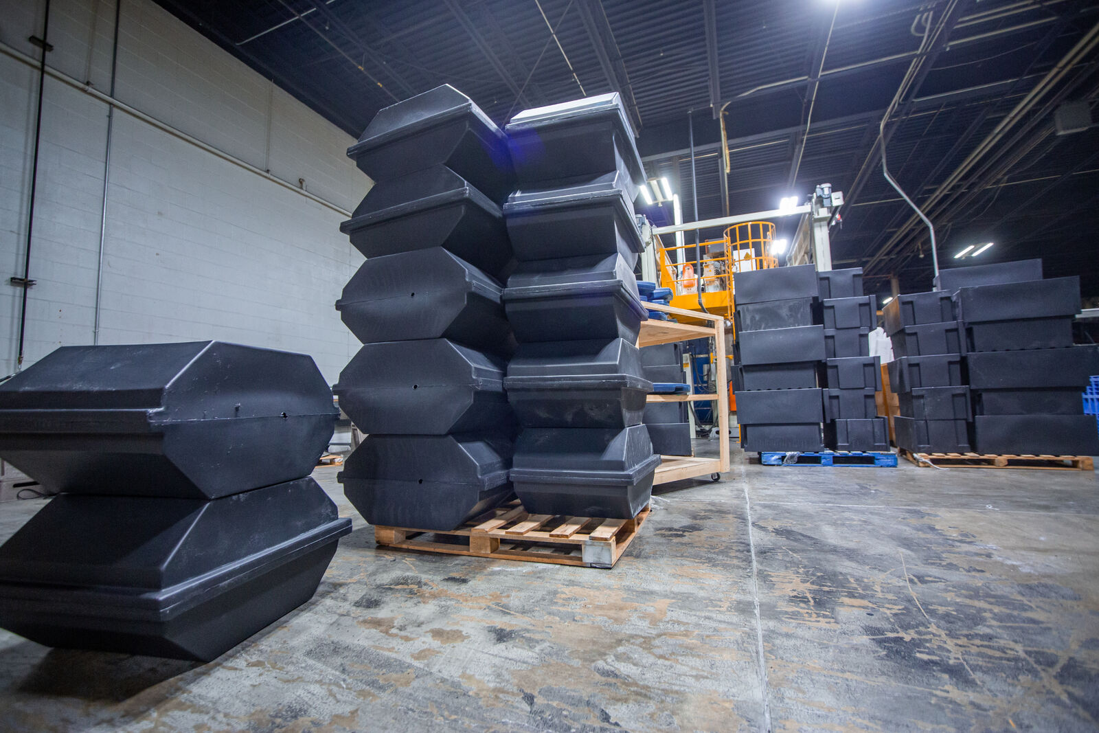 Black, rotomolded tank molds stacked in a warehouse